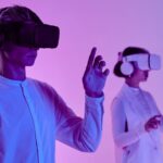Two people engage in a futuristic virtual reality simulation with headsets and vibrant lighting.